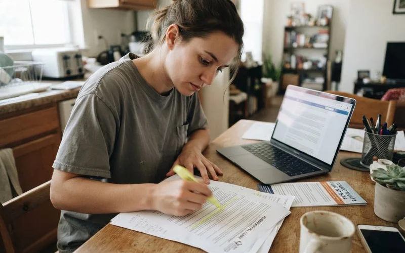 A renter reviewing a printed copy of a lease agreement with sections highlighted